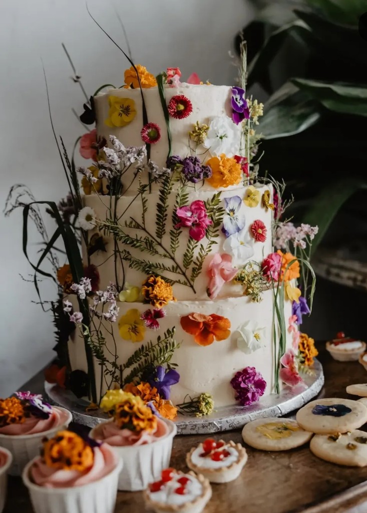 Tarta floral con flores comestibles, cupcakes y tartaletas